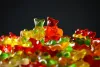 Colorful gummy bears piled together against a dark background
